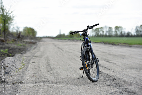 Mountain bike. stands on a field road. spring or autumn. concept of cycling, repair or breakage, sports, outdoor activities. bike on trail, front wheel in focus. healthy lifestyle