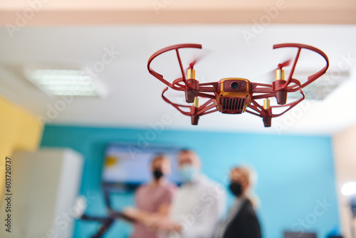  A group of students working together in a laboratory, dedicated to exploring the aerodynamic capabilities of a drone