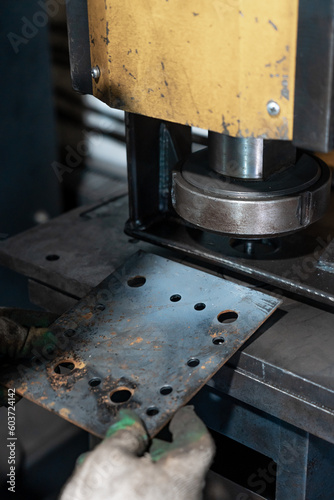 Holds a metal sheet with holes in the background hole-punching machine