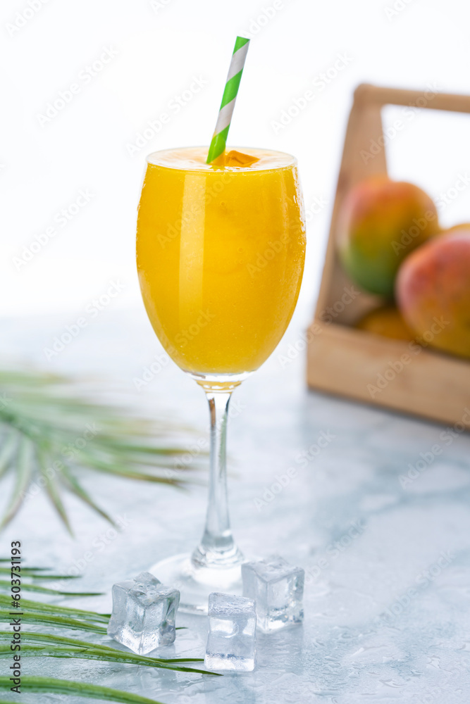 Fresh mango juice in a glass with ice cubes 