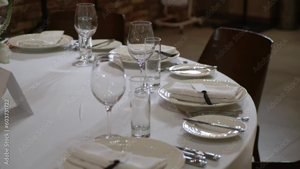 Served tables for a holiday in a restaurant. Glasses, plates, cutlery, napkins. Wedding decor, celebration dinner or party, reception indoors. No food. Served tables for a holiday in a restaurant. Glasses, plates, cutlery, napkins. Wedding decor, celebration dinner or party, reception indoors. No food.