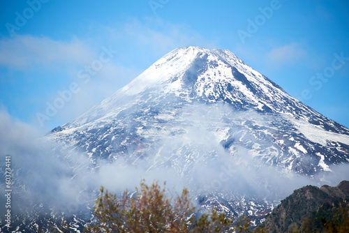 View of the Villarrica volcano during the autumn season with snow on its summit.