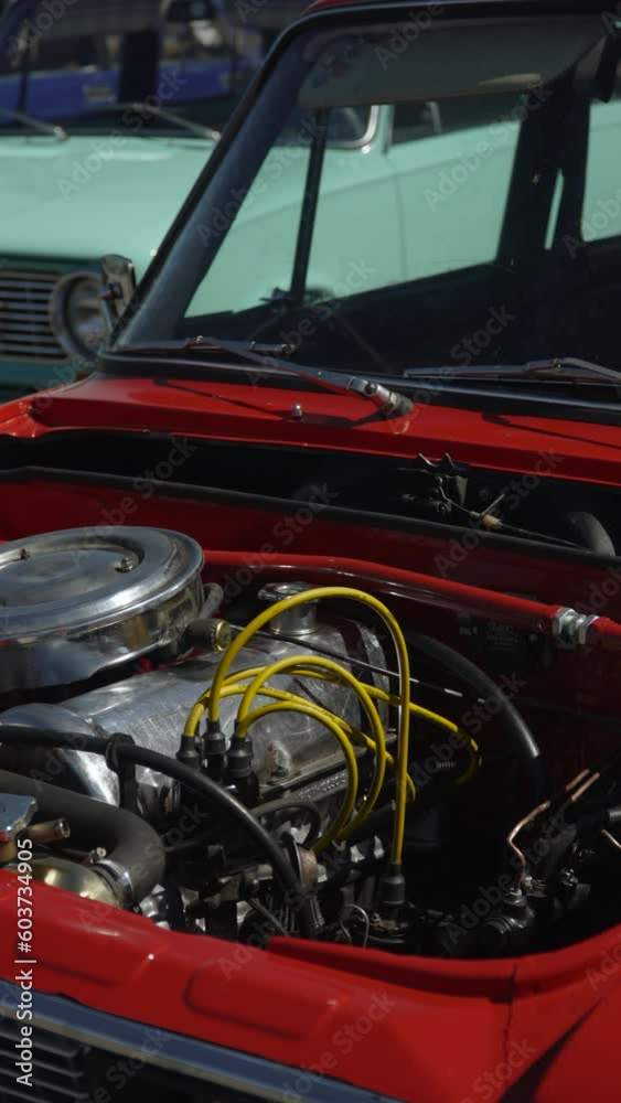 Old car without hood stands on open air site in retro car restoration workshop. Clean shiny carbureted engine with new wires and fuel rail with polished shiny air intake, vertical video. Old car without hood stands on open air site in retro car restoration workshop. Clean shiny carbureted engine with new wires and fuel rail with polished shiny air intake, vertical video.