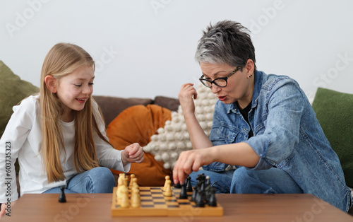 Fun pastime of an adult with a child, playing chess in a home interior.
