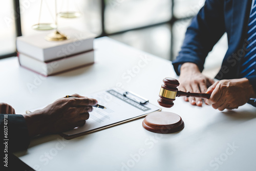 concept of justice and law A male judge in the courtroom on a wooden table and a male counselor or lawyer working in the office. Law  advice and justice concepts.