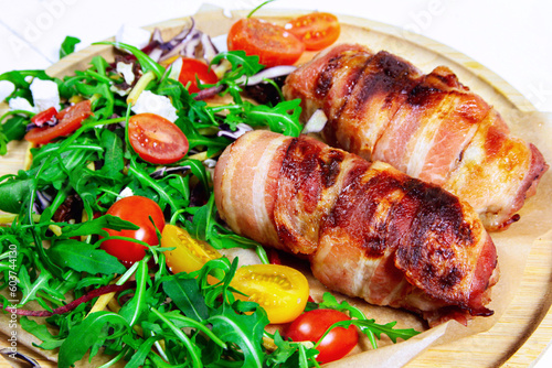 Pork rolls wrapped in bacon served with salad