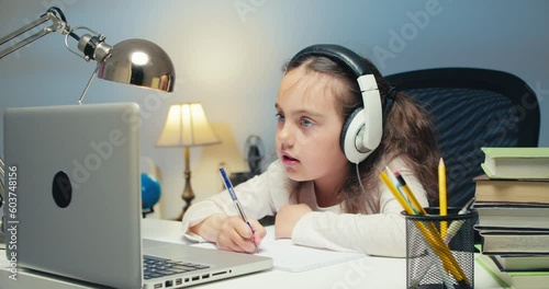 Girl Child Studying in Online Kolas at Home. Back to School, Online Learning, Distance Lesson, Homeschooling, School Technology, Tutored Lessons. Children Doing Homework at Home photo