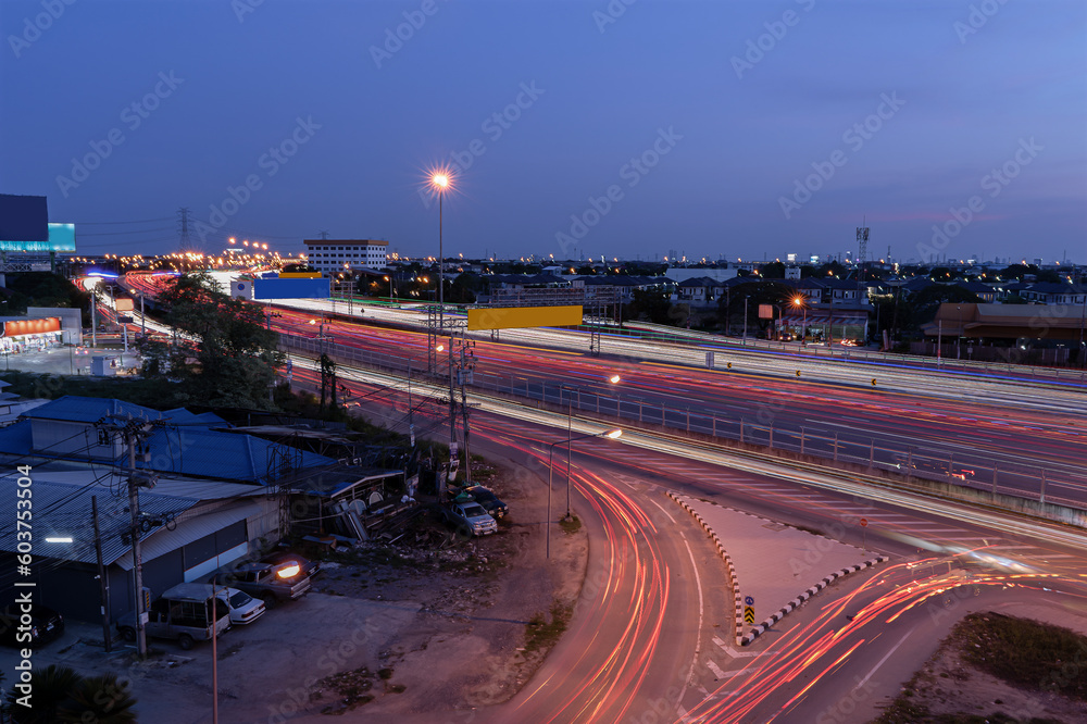 Long exposure shot of traffic while traveling at night on a motorway in Thailand. Abstract animated curved city road with neon light motion effect applied.