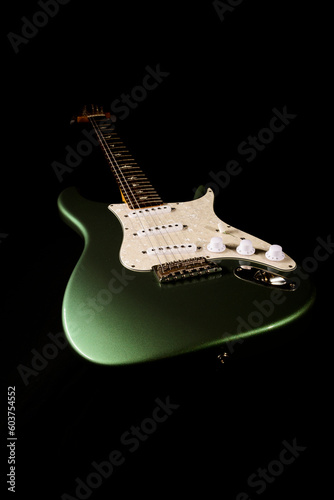 Stratocaster style electric guitar floating on black background