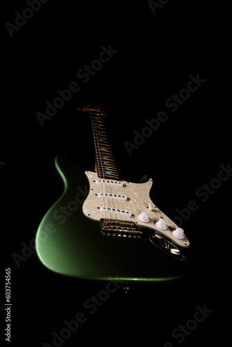 Stratocaster style electric guitar floating on black background