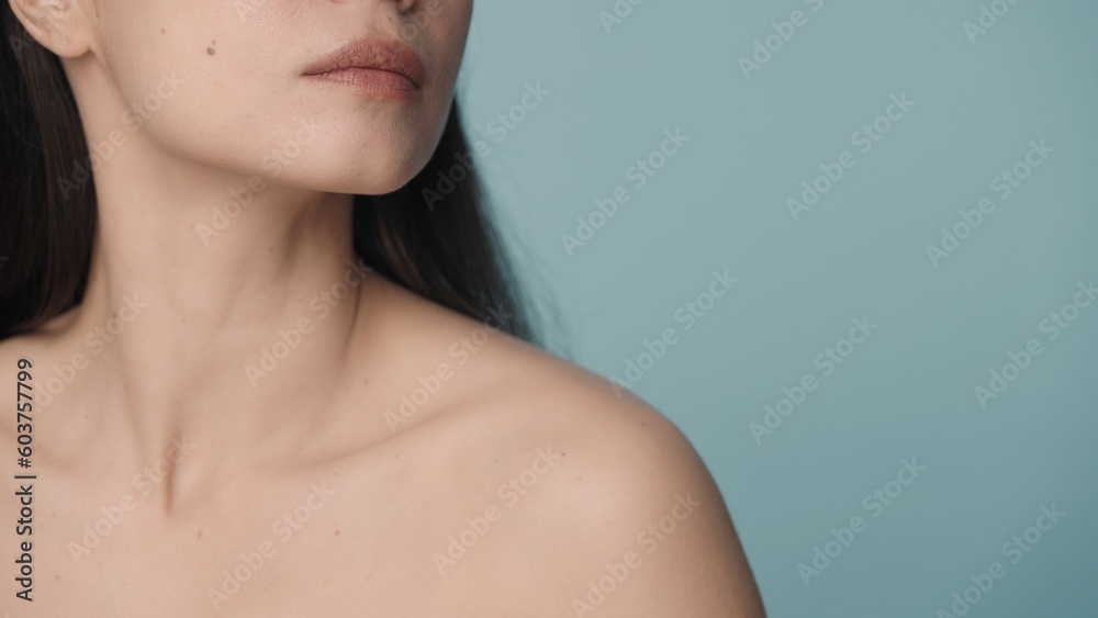 Perfect chin, slender neck and naked shoulders of a woman on a blue background close up. Skin care, body care, cosmetology, plastic surgery Perfect chin, slender neck and naked shoulders of a woman on a blue background close up. Skin care, body care, cosmetology, plastic surgery