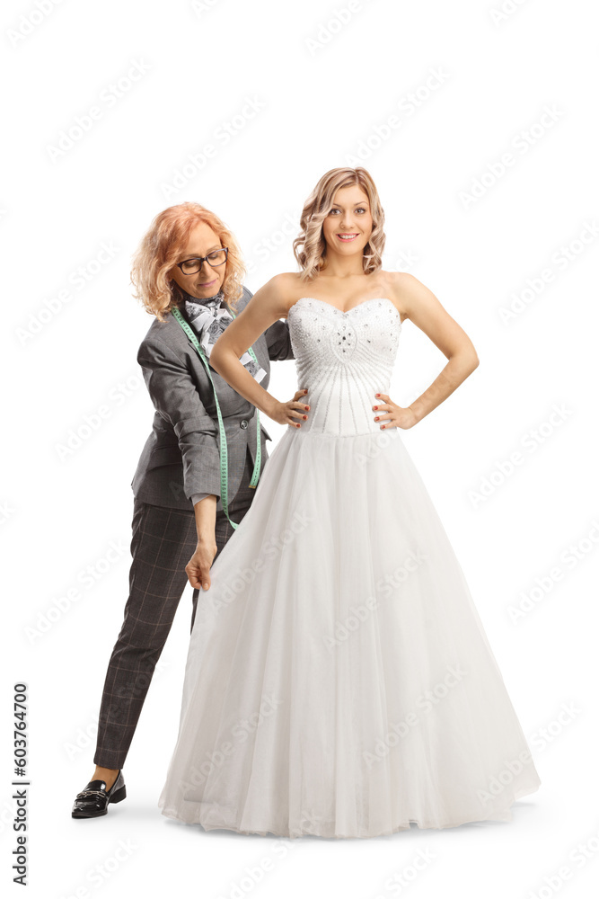 Bride trying on a down and seamstress taking measures Bride trying on a down and seamstress taking measures