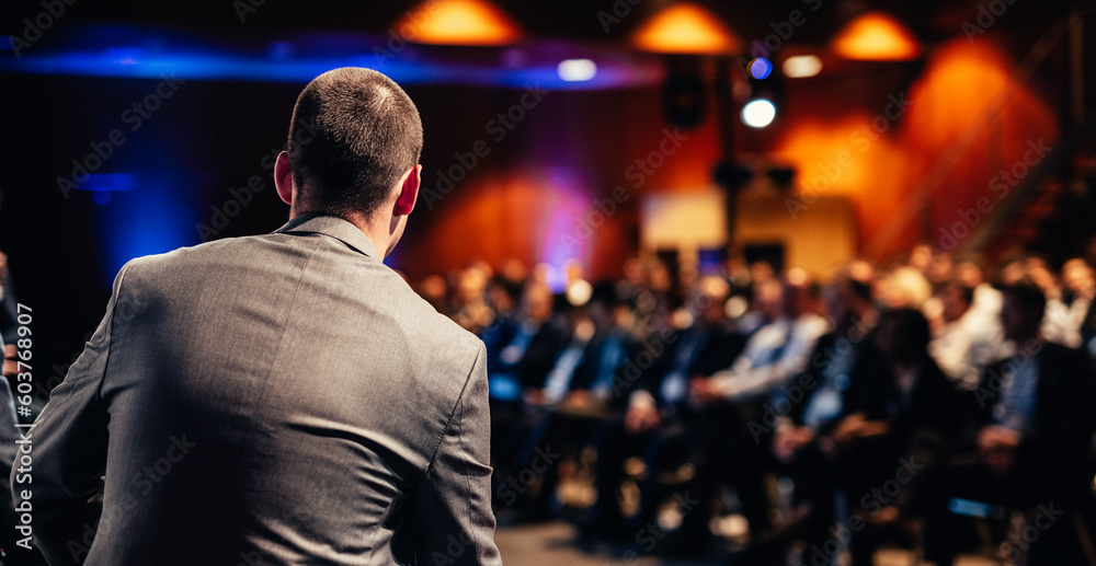 Speaker giving a talk on corporate business conference. Unrecognizable people in audience at conference hall. Business and Entrepreneurship event. Speaker giving a talk on corporate business conference. Unrecognizable people in audience at conference hall. Business and Entrepreneurship event.
