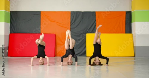 Little girls practice at gymnastics class in a studio