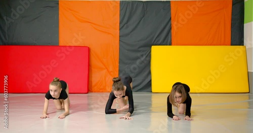 Little girls practice at gymnastics class in a studio