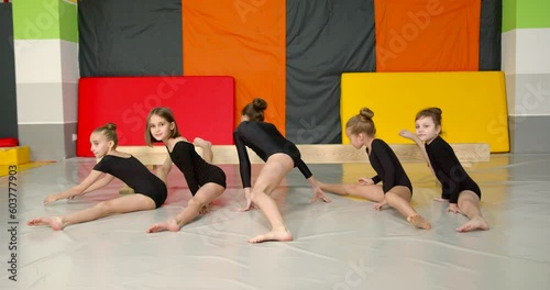 Little girls practice at gymnastics class in a studio