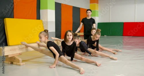 Little girls practice at gymnastics class in a studio