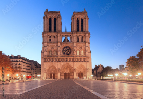 Facade of Notre Dame Cathedral building at sunrise.