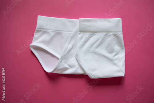 Step 3: fold the right side to the middle. Women's stylish high briefs on a pink background. Organization, storage of underwear, method, perfectionism, Japanese, minimalism, wardrobe. Feminine hygiene