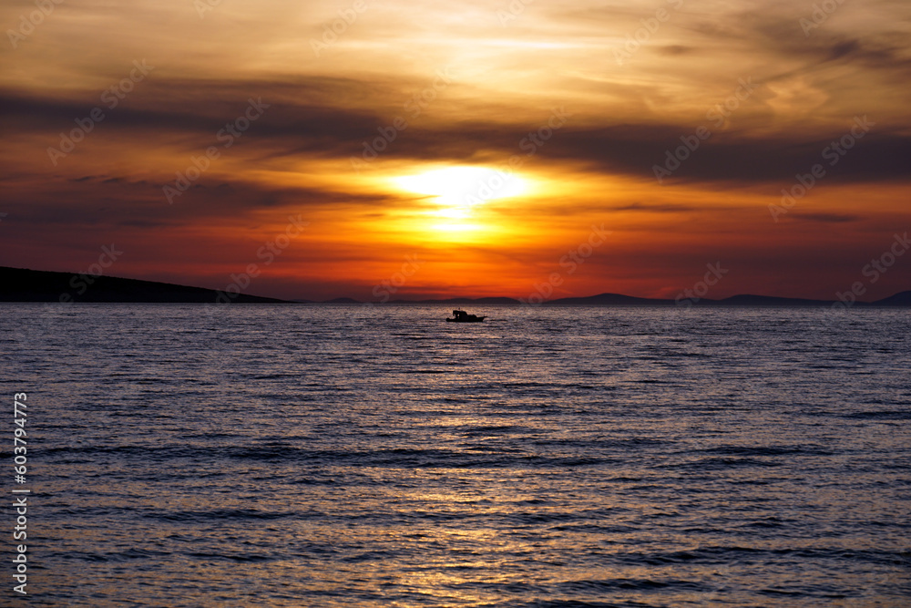 Colorful sea sunset with purplish sea surface and orange dramatic sky Colorful sea sunset with purplish sea surface and orange dramatic sky