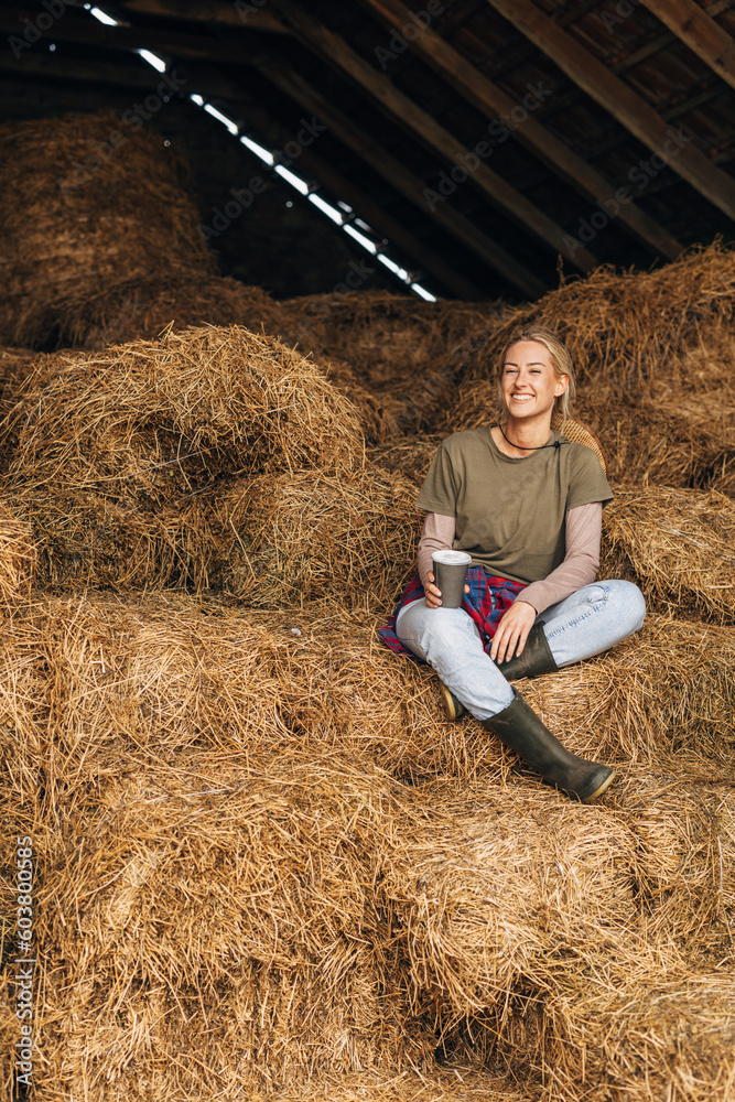 A beautiful Caucasian woman sits in a pile of hay A beautiful Caucasian woman sits in a pile of hay