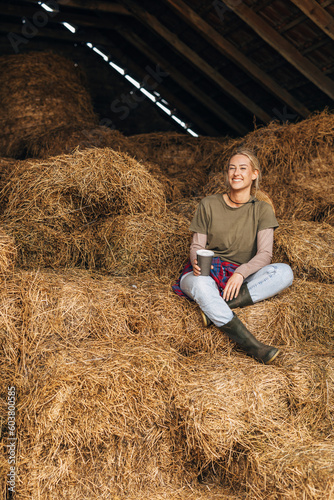 A beautiful Caucasian woman sits in a pile of hay