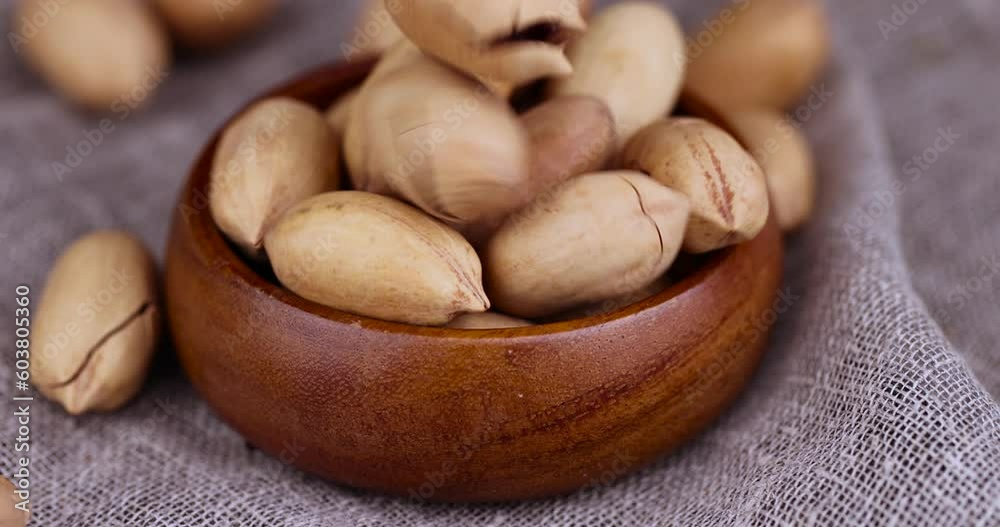 pour unpeeled crunchy pecans close-up, a large number of unpeeled pecans in the kitchen pour unpeeled crunchy pecans close-up, a large number of unpeeled pecans in the kitchen
