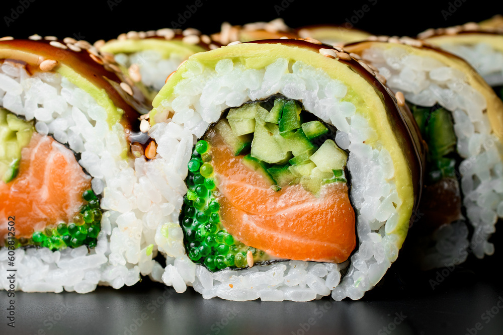 Asian sushi rolls with salmon, avocado, cucumber and green caviar poured with teriyaki sause. Asian sushi rolls with salmon, avocado, cucumber and green caviar poured with teriyaki sause.