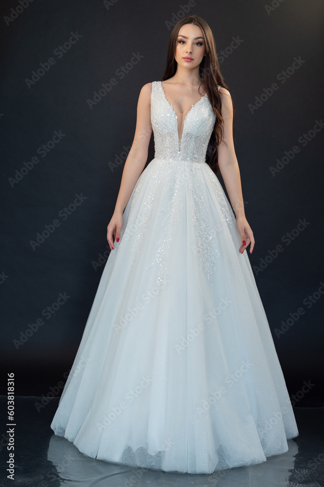 Beautiful bride in wedding dress on black background