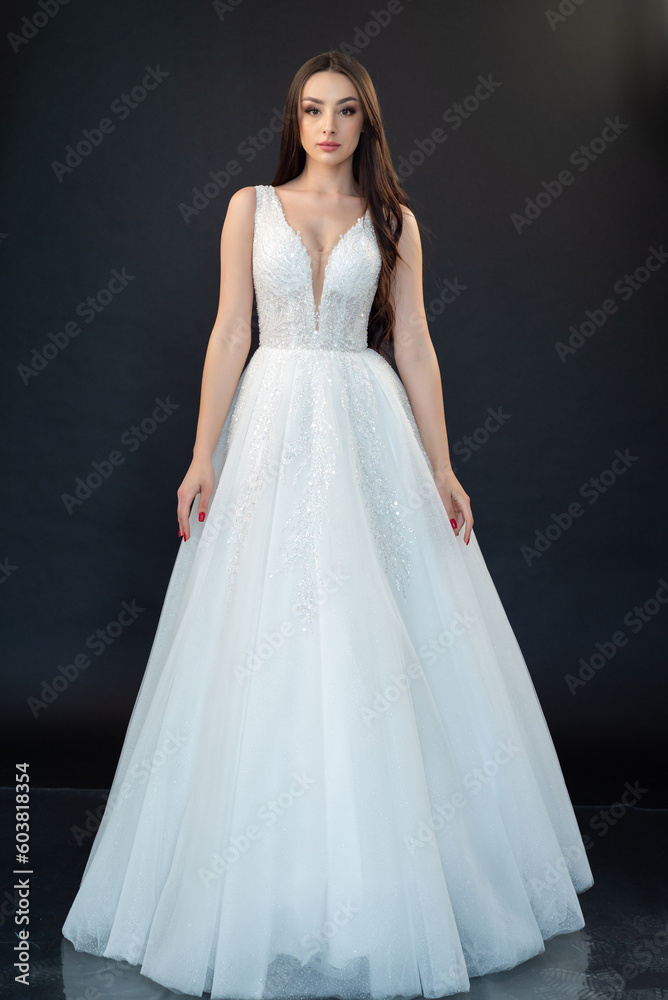 Beautiful bride in wedding dress on black background