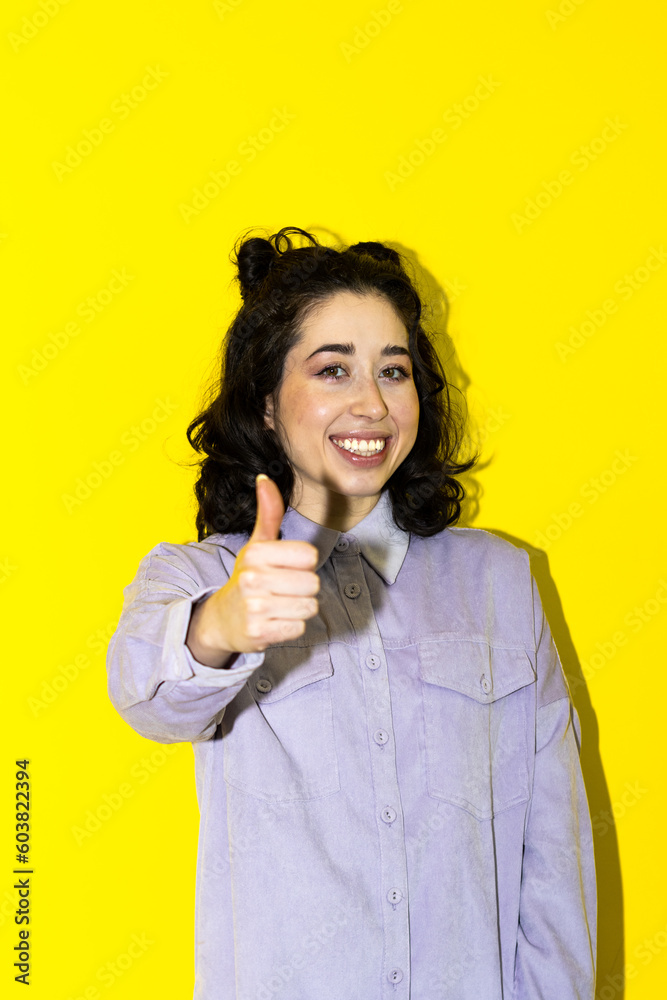 Positive latin young woman showing thumb up looking at camera, checking for good quality recommendation isolated in yellow background. Well done! Great job! Positive latin young woman showing thumb up looking at camera, checking for good quality recommendation isolated in yellow background. Well done! Great job!