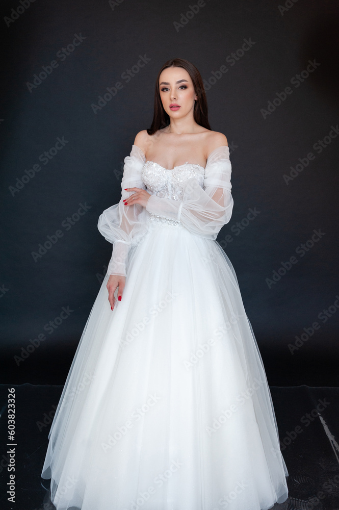 Beautiful bride in wedding dress on black background