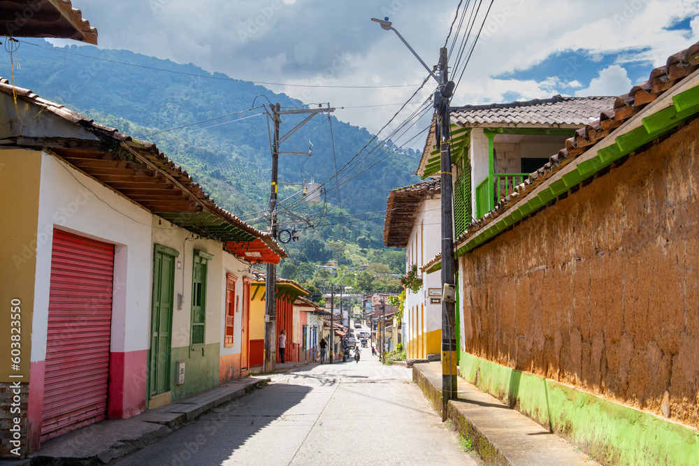 Streets of a town in Colombia, where you can see people walking through colored houses. Town in the mountains of Latin America.