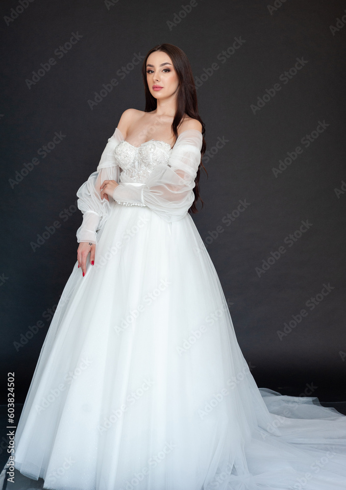  Beautiful fashion bride posing in wedding dress on black background 