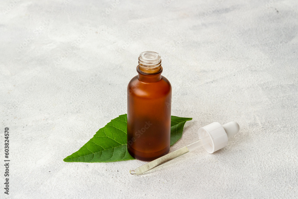 Herbal or tea tree essential oil in dropper bottle. Cosmetic products concept