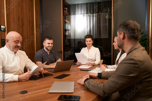 Smiling female reading papers in the cabinet