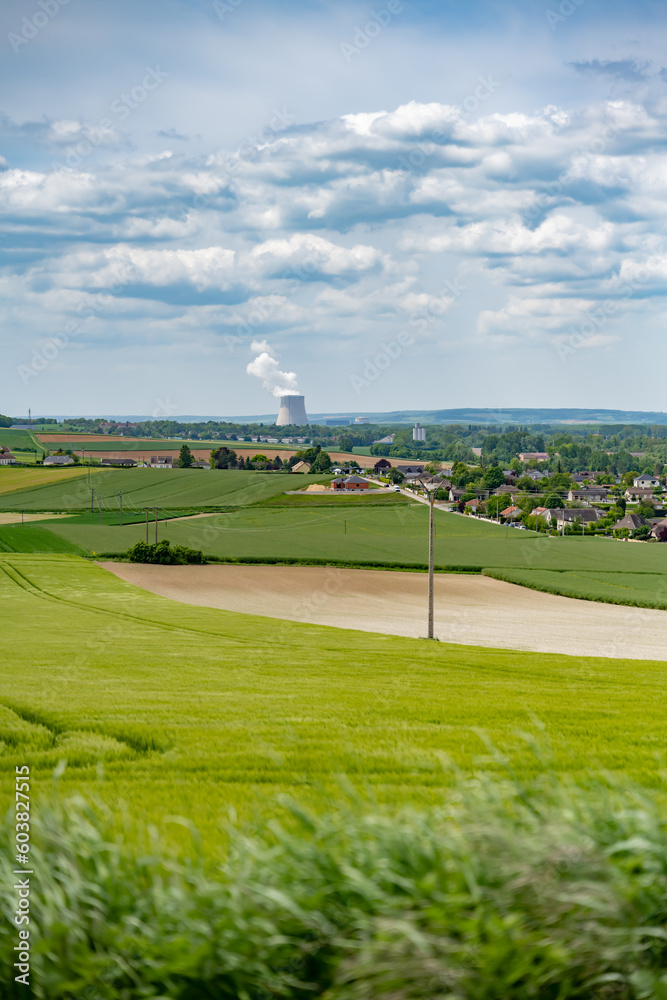 Centrale nucléaire à l'horizon avec des champs et des villages