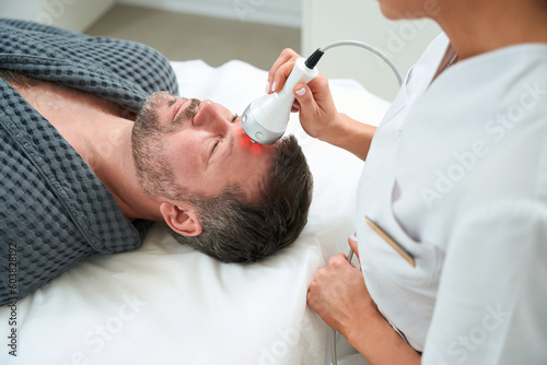 Close up photo of female cosmetologist treating man