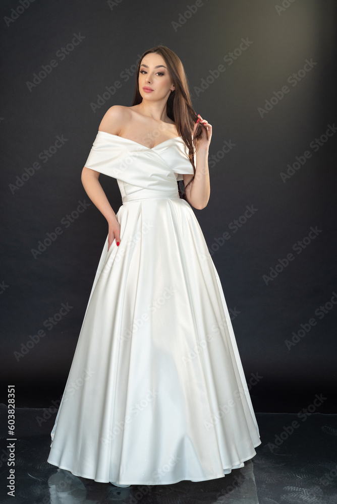 Beautiful fashion bride in wedding dress posing ob black background