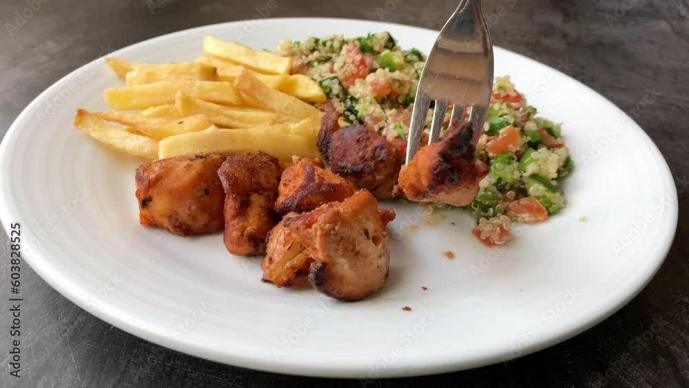 Eating a Plate of Chicken Sis with French fries and Tabbouleh Eating a Plate of Chicken Sis with French fries and Tabbouleh