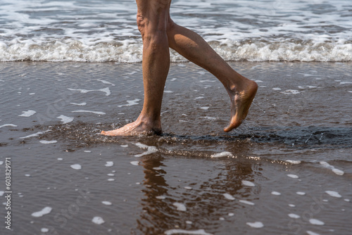 Barefoot woman walking on the seashore at the beach. © fotosdanielgbueno