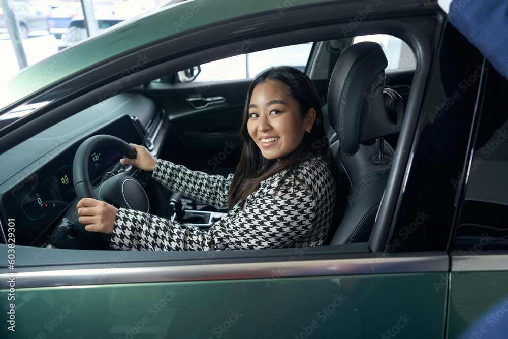 Young female customer is testing a new car Young female customer is testing a new car