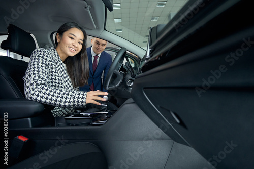 Young asian woman inspects the interior of acar before buying photo