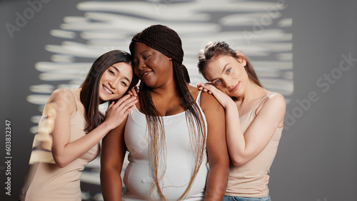 Beautiful luminous girls promoting self acceptance on camera, having glowing radiant skin posing in studio. Happy beauty models emrabcing imperfections in new wellness campaign.