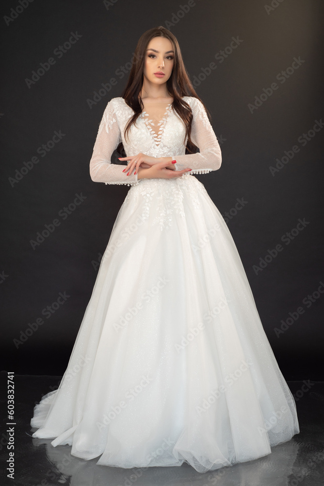  Beautiful fashion bride posing in wedding dress on black background 