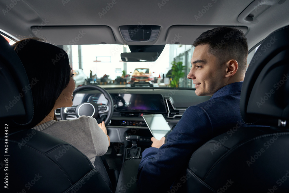 Young woman in the drivers seat chats cutely witha man