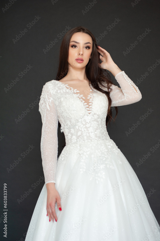Beautiful fashion bride posing in wedding dress on black background Beautiful fashion bride posing in wedding dress on black background
