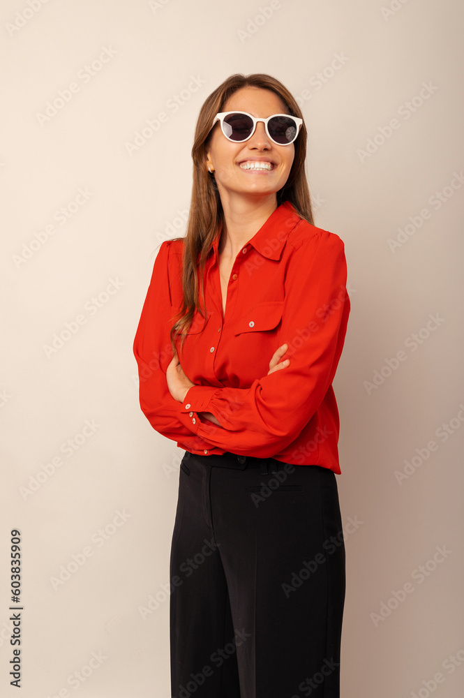 Vertical portrait of a woman wearing sunglasses is standing with arms crossed. Vertical portrait of a woman wearing sunglasses is standing with arms crossed.