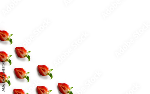 Strawberries in the corner of the frame on a white background. Pattern of halves of berries with a place for text. Top view. Flat lay