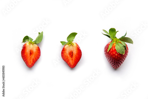 Strawberries on a white background. One whole berry and two halves of juicy fruit. Flat lay with Space for text.